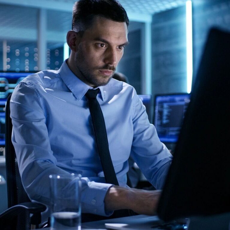 Focused man in business attire working on a computer in an office.